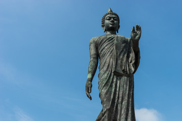 Fototapeta na wymiar Standing Buddha statue and sky backgroud in Thailand
