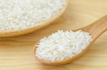 white rice grains with wooden spoon.