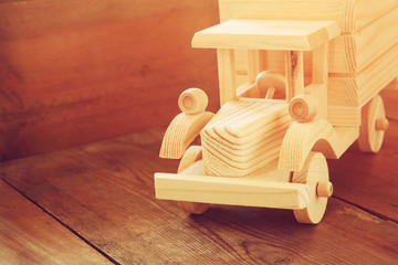 Fototapeta na wymiar retro wooden toy car over wooden table. room for text. nostalgia and simplicity concept. retro style image 