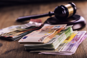 Judge's hammer gavel. Justice and euro money. Euro currency. Court gavel and rolled Euro banknotes. Representation of corruption and bribery in the judiciary.