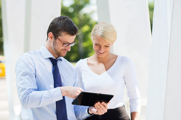 Businesspeople having a meeting outdoors with tablets.