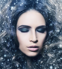 Beauty portrait of a young and gorgeous woman in snowflakes.