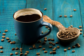 coffee Cup and beans on a blue wooden background