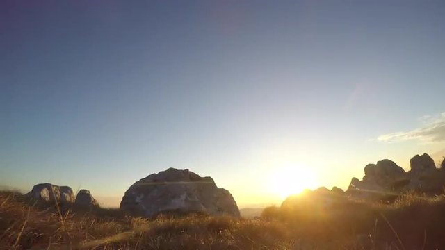 Hiker walking in sunset on mountain plateau