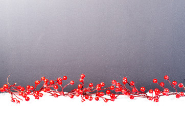 Christmas branch with red berries on snow. Christmas and New Year decoration. Free space for text