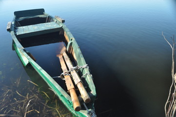 Rowing boat moored to the shore. Spring on the river. Floating.
