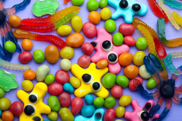 Fototapeta na wymiar multi-colored jelly candy in the shape of a worm and the spider are mixed with candy 