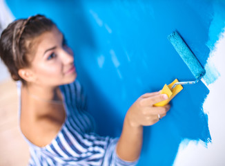 Happy beautiful young woman doing wall painting