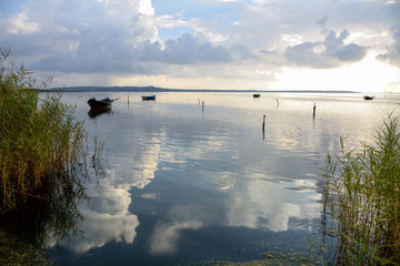 Fishermen Boat Sunset Lagoon / Sunset in the lagoon, where fishermen return to the approach of the impending storm. Dawning. Sardinia Mediterranean islands.