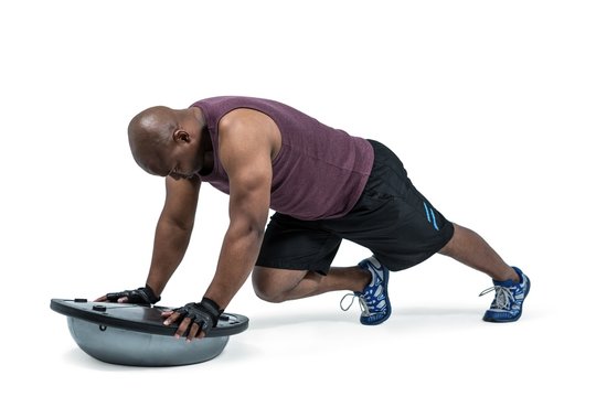 Fit man exercising with bosu ball