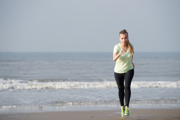 Fit young woman running at the beach