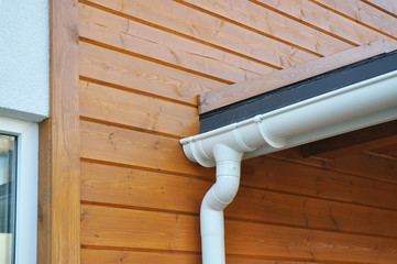 Closeup of problem areas for bitumen membrane rain gutter waterproofing and plastic drain downspout system.
