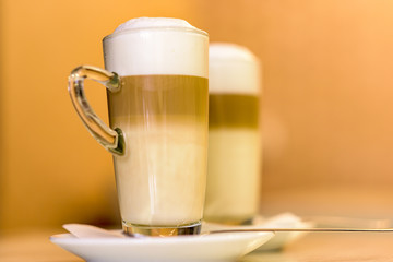 Two cappuccino glasses on a restaurant table, close up