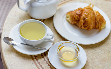 French croissant on white plate on a restaurant table