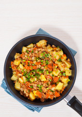 stewed potato with minced meat in a frying pan