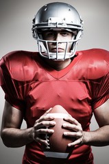 Composite image of american football player holding ball