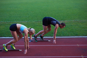 woman group  running on athletics race track from start