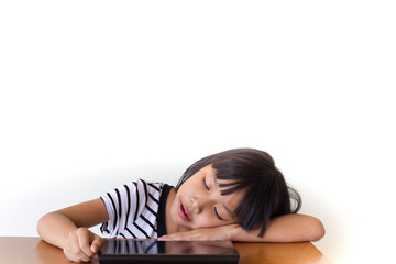 Obraz premium Little girl with bored tablet pc sitting on the wooden table - Technology and children concept