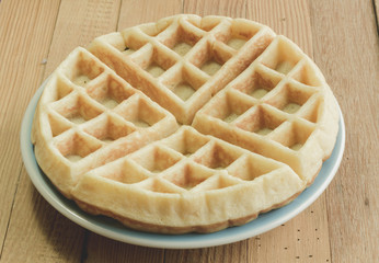 Full waffle with blue dish on the wooden background - Vintage Filter Effect