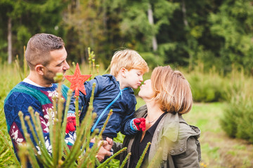 Happy Family Decorating an Outdoors Fir Tree for Christmas