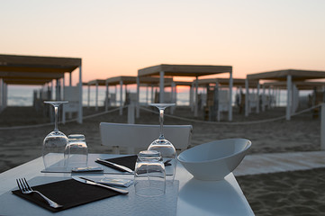 Dining table prepared for two on sand beach at sunset © RiumaLab