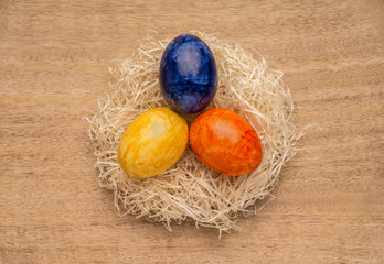 Hintergrund Ostereier im Strohnest auf Holzhintergrund