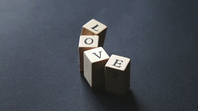 hands playing with alphabet stamps and the word "love"