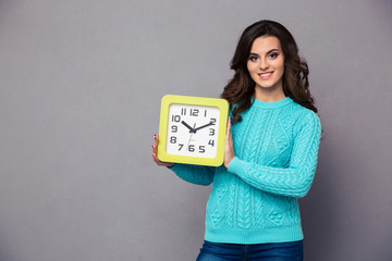 Happy woman holding wall clock