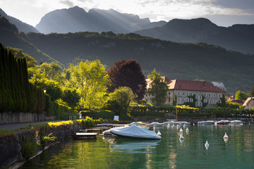Morgensonne scheint in den Hafen von Talloires am Lac d'Annecy vor dem Bergmassiv der Tournette - obrazy, fototapety, plakaty
