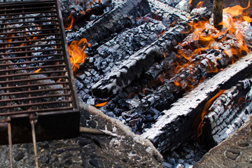 Burning fire with coals and grill for barbecue and grilling.
