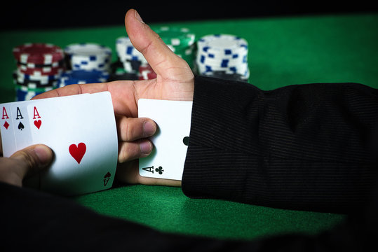 Man with ace up his sleeve, cheating at poker.