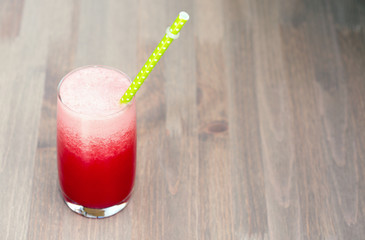 A glass of fresh watermelon smoothie on wooden background