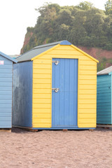 Fototapeta na wymiar A blue and yellow wooden beach in Teignmouth, Devon, England