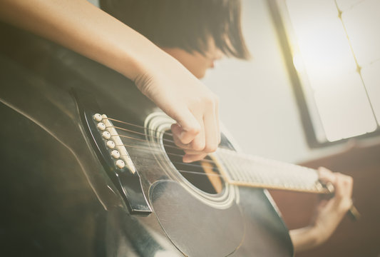 girl playing black guitar