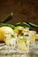Carbonated lemonade with lemon slices and mint on an old wooden