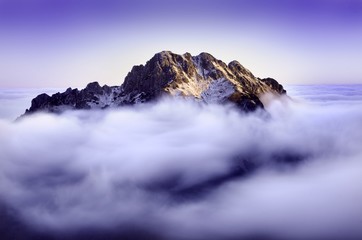 Obraz premium Early morning in a Low Fatra, In the middle of picture is hill and around it is a fog. Natural background with blue colour