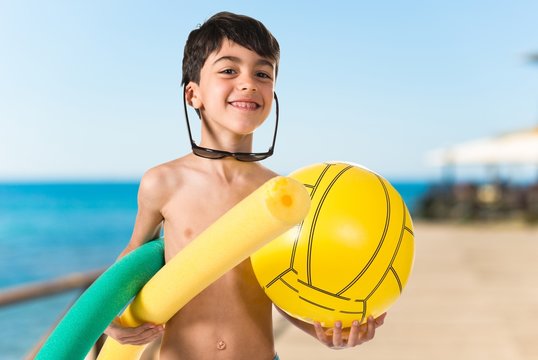 Child holding beach elements