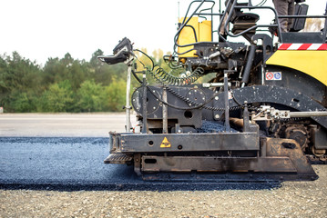 industrial pavement truck laying fresh asphalt on construction site, asphalting .