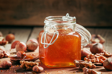 Sweet Amber mountain honey with hazelnuts and walnuts on an old