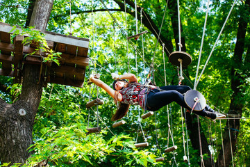Adventure climbing high wire park - woman on course in mountain