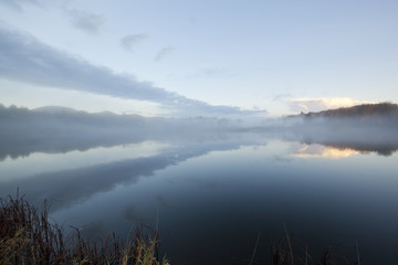 Fototapeta na wymiar A foggy sunrise on Onota Lake in the Berkshire Mountains of Western Massachusetts.
