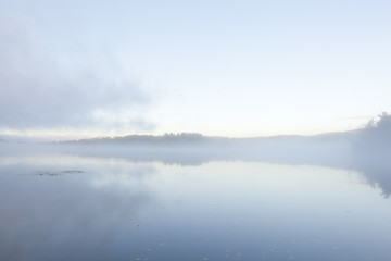 Naklejka na ściany i meble A foggy sunrise on Onota Lake in the Berkshire Mountains of Western Massachusetts.