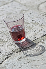 Glass of red wine on the ground in Venice, Italy