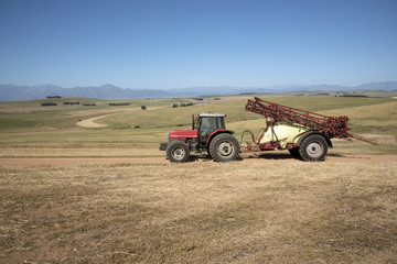 Obraz premium Farm tractor and crop sprayer in the Swartland region of South Africa
