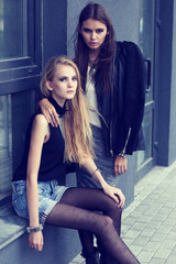 Two young fashion women posing outdoor.