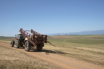 Fototapeta premium Farm tractor and crop sprayer in the Swartland region of South Africa