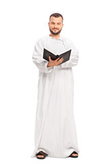 Religious man in a white robe holding a holy book