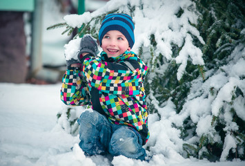 Happy young child in white winter snowy landscape