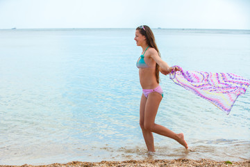 Fototapeta na wymiar Happy teen girl having fun on a beach