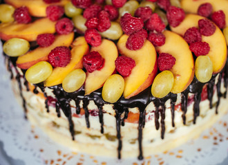 Fruit, cake naked. homemade cake with raspberries, grapes, and p